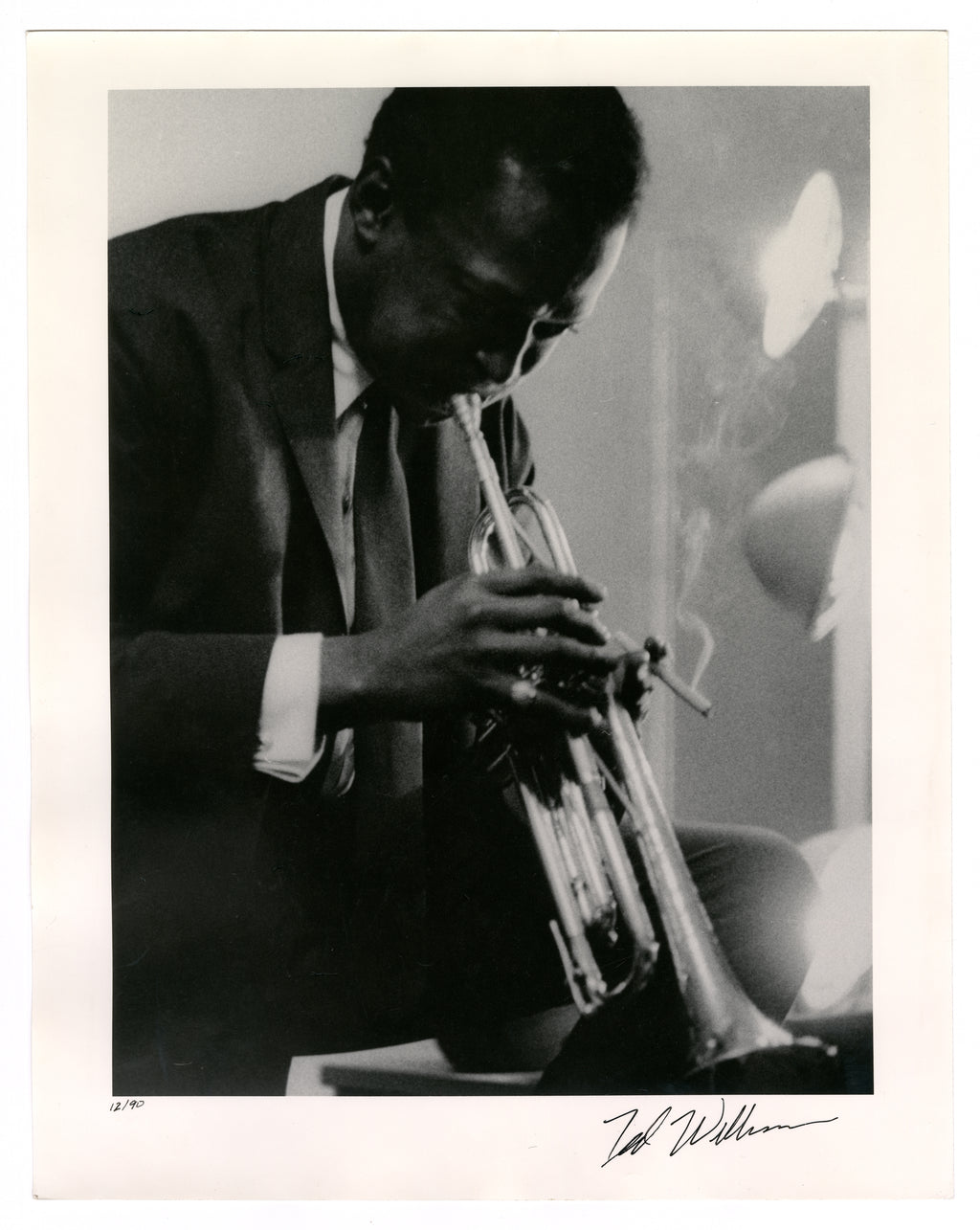 MILES DAVIS PLAYING THE TRUMPET IN A DRESSING ROOM BEFORE A PERFORMANCE BY TED WILLIAMS